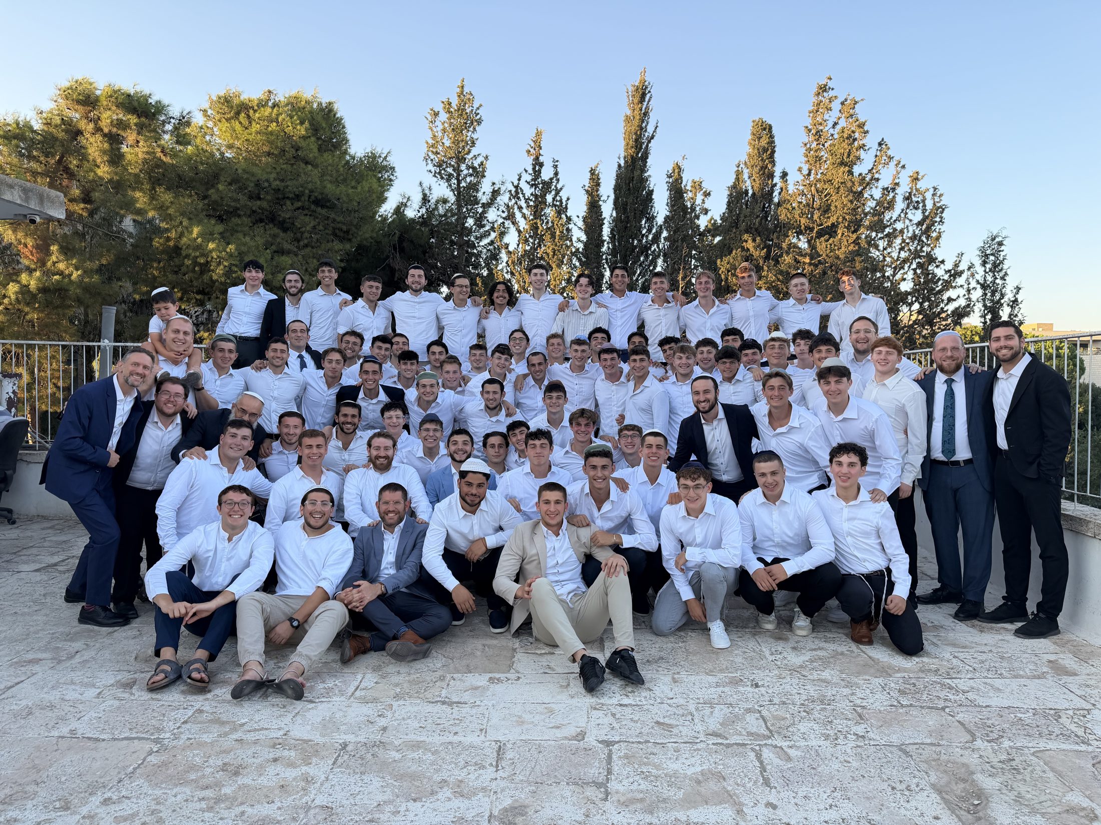 The whole yeshiva together in white on the campus terrace